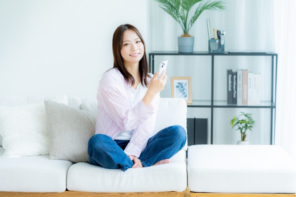 スマホを手に微笑む女性